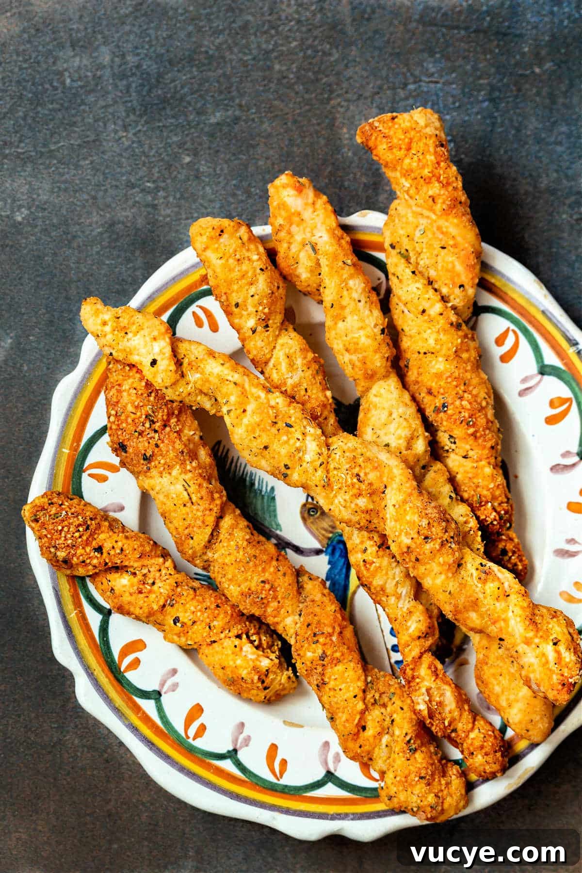 Crispy Puff Pastry Cheese Straws Recipe 6 Puff pastry cheese straws on a plate, shot from above.