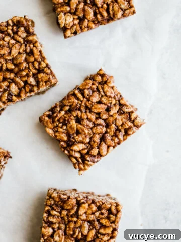 Chocolate squares made with rice cereal on parchment paper.