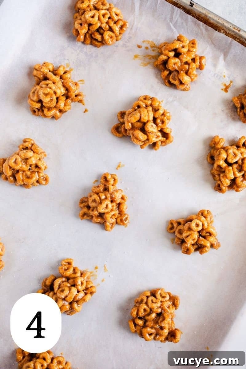 3-Ingredient Peanut Butter Cereal Bites Recipe 7 Mounds of peanut butter balls on a baking sheet.