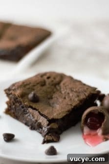 Chocolate Cherry Brownies with Gooey Chocolate Ganache 6 Chocolate Covered Cherry Cordial Brownies on a plate.