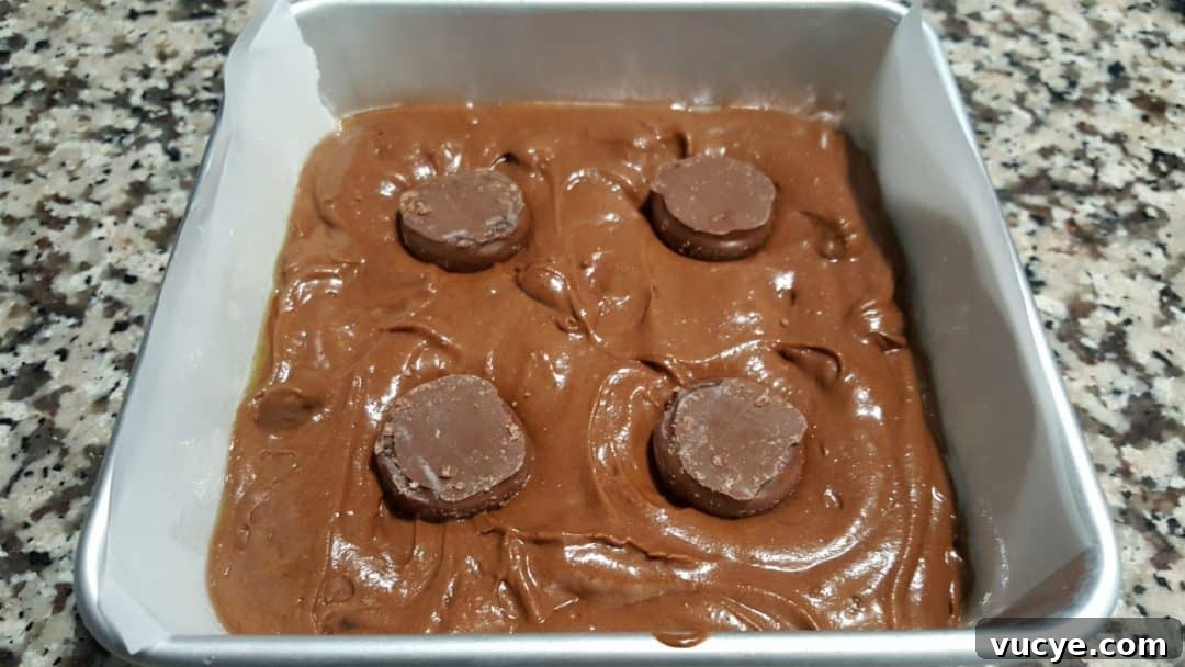 Chocolate Cherry Brownies with Gooey Chocolate Ganache 4 a cake pan filled with brownie batter and 4 upside-down chocolate covered cherries