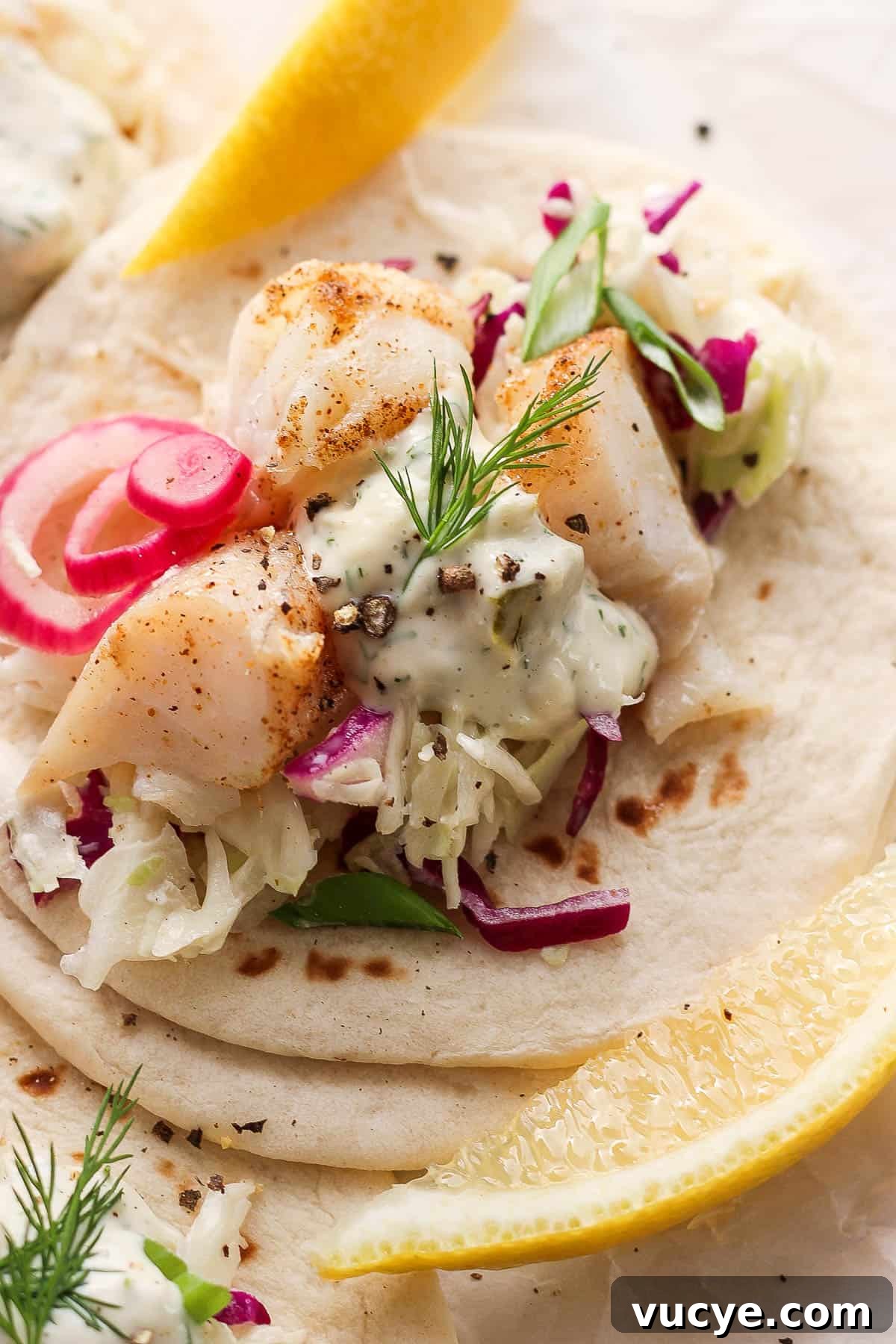 Crispy Cod Tacos with Zesty Slaw and Lime Crema 7 Cod taco topped with creamy slaw, pickled red onion, all on a flour tortilla.