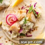 Crispy Cod Tacos with Zesty Slaw and Lime Crema 8 Top down shot of a cod taco with fresh tartar sauce, dill and quick pickled onions.