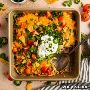 Top Rotisserie Chicken Recipes You’ll Want to Try 2 Chicken taco bake in pan with serving spoon scooping in.
