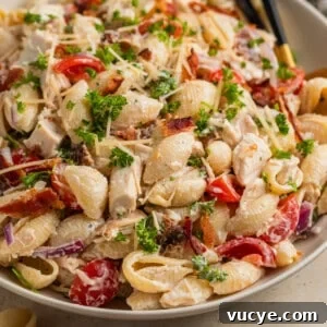 Top Rotisserie Chicken Recipes You’ll Want to Try 11 Dish with chicken bacon pasta salad and serving spoon.
