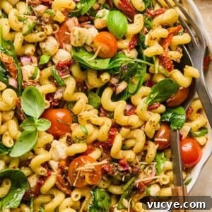 Top Rotisserie Chicken Recipes You’ll Want to Try 13 Pasta salad with sun dried tomatoes, spinach, basil and other ingredients in serving bowl.
