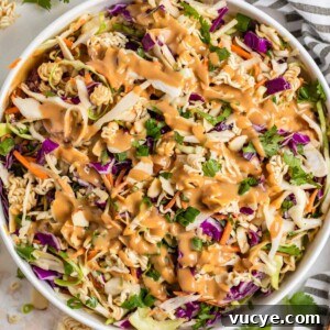 Top Rotisserie Chicken Recipes You’ll Want to Try 19 Ramen cabbage salad with peanut dressing over top in white bowl.