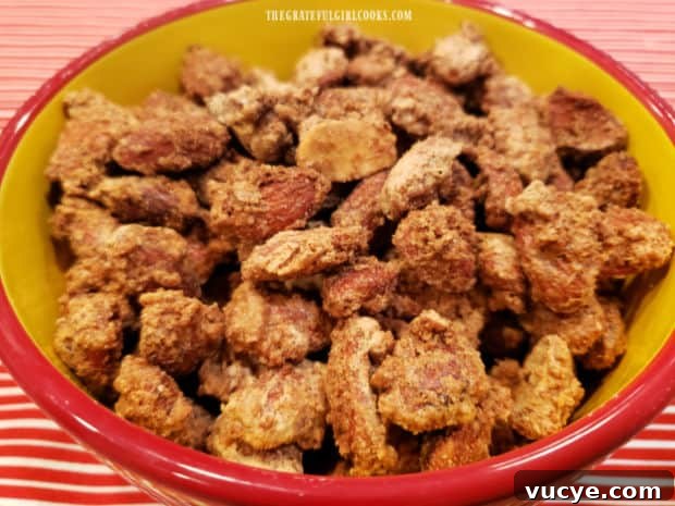 Serve almonds A yellow bowl with red trim, full of cinnamon glazed almonds, ready to be eaten.