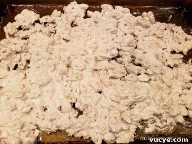 Spread almonds on baking sheet Cinnamon glazed almonds are combined with melted butter and spread out on baking sheet.
