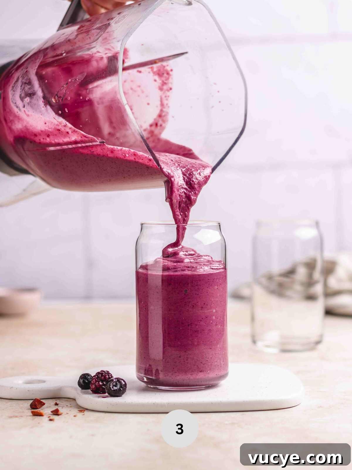 Pouring the smoothie into a serving glass.