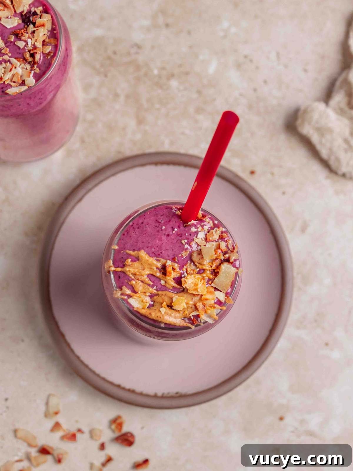 Smoothies garnished with coconut bits and almond butter drizzle.