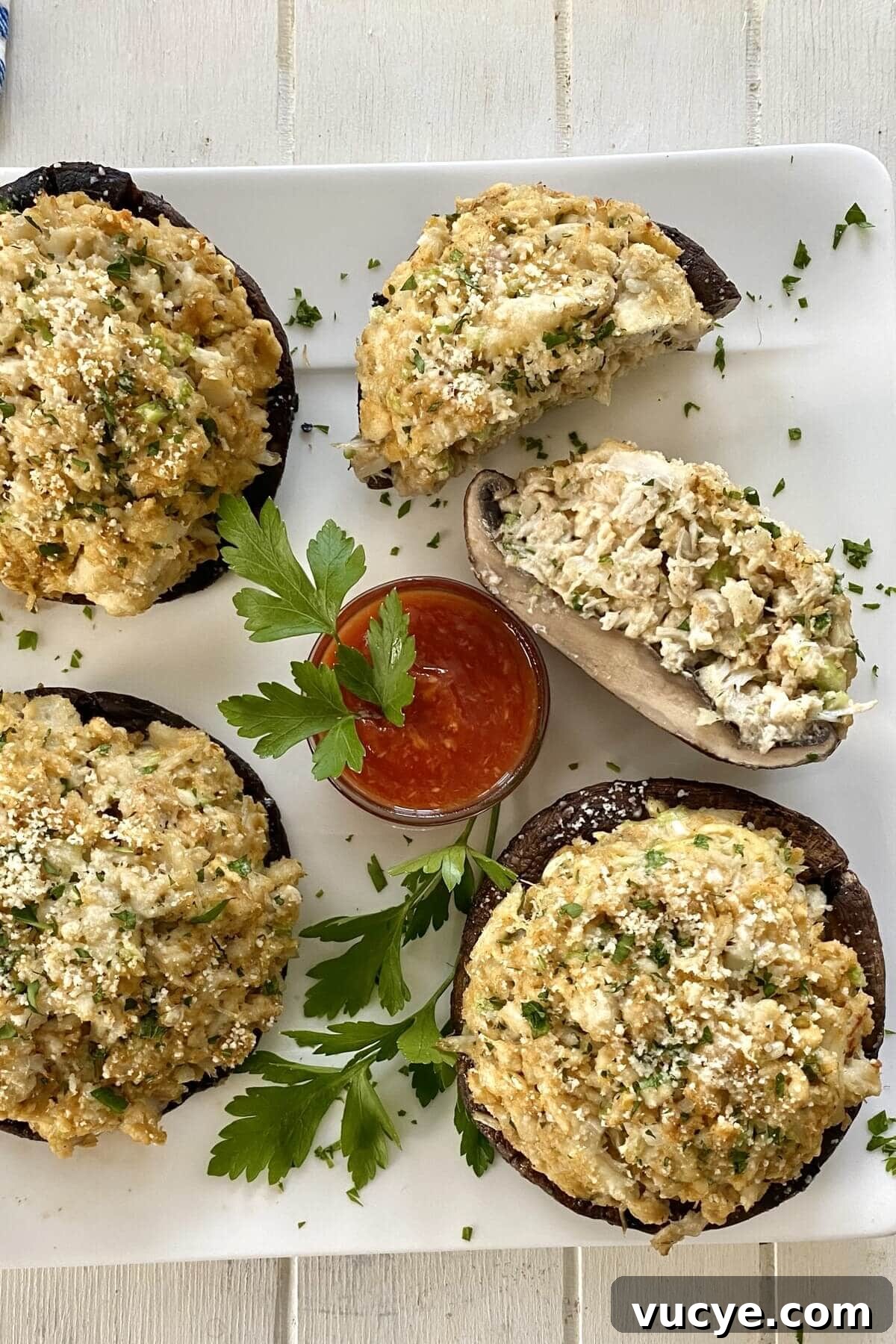 Crab-Stuffed Portobello Mushrooms with Garlic Herb Filling 3 4 crab stuffed mushrooms with cocktail sauce.