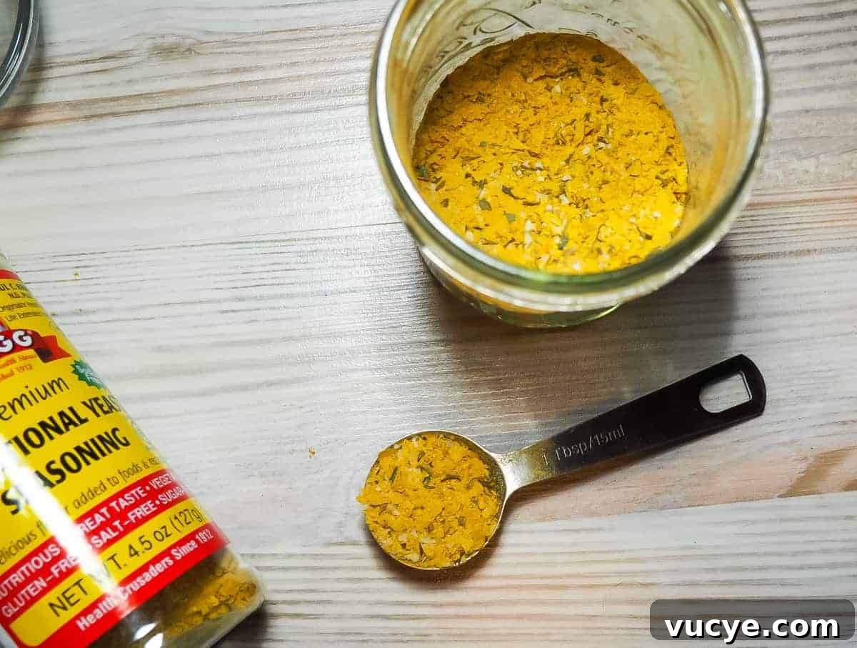 A jar of mixed homemade chicken bouillon with a spoon full of bouillon.