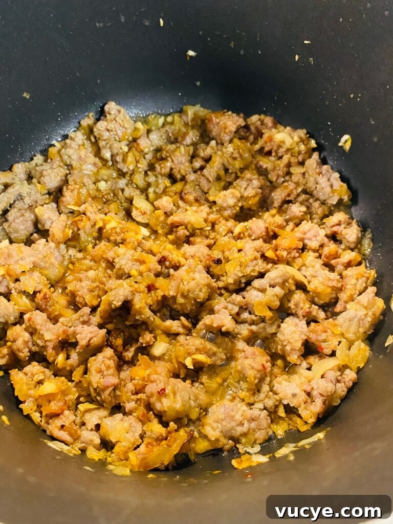 Creamy Italian Sausage and Kale Soup Recipe 5 Cooked sausage and onions in a soup pot