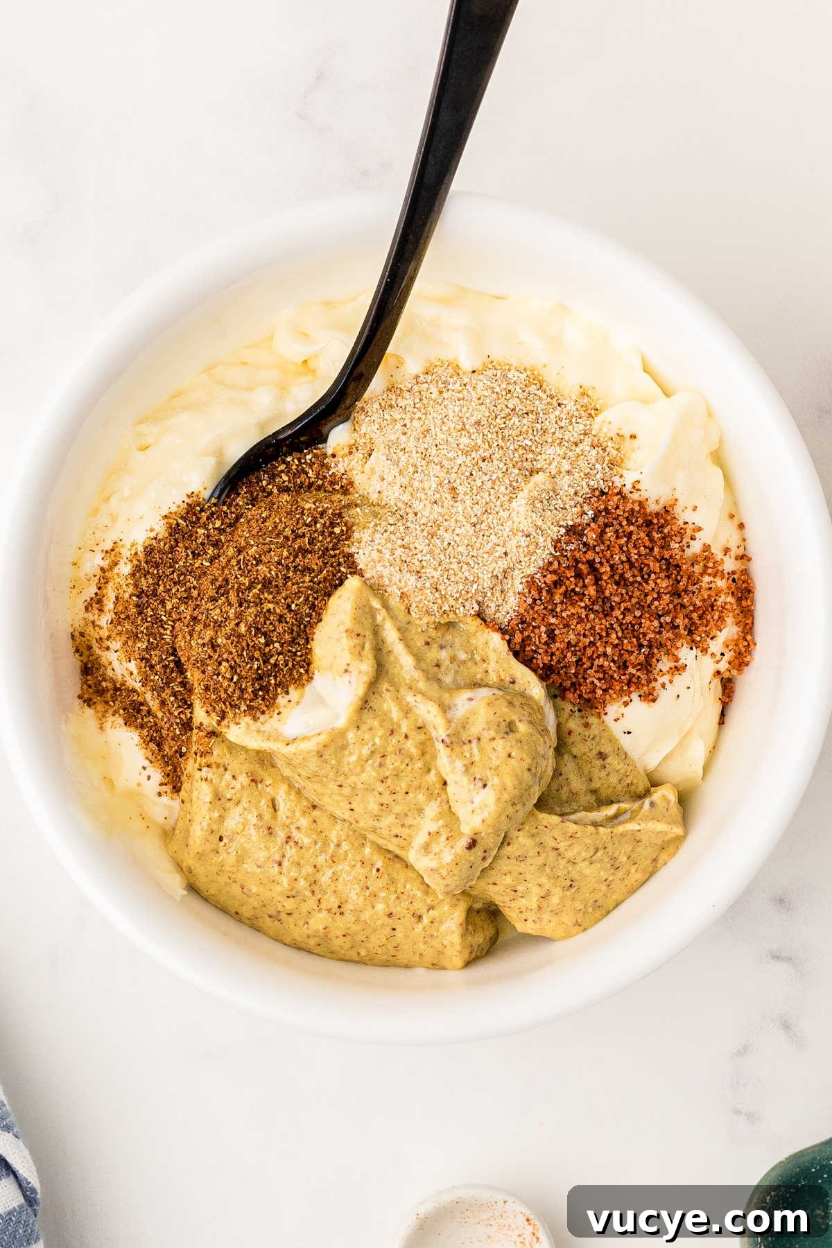 Crispy Fried Boudin Balls: Where to Find & How to Enjoy 12 Close up image of a bowl of the ingredients needed to make a mustard cream sauce.