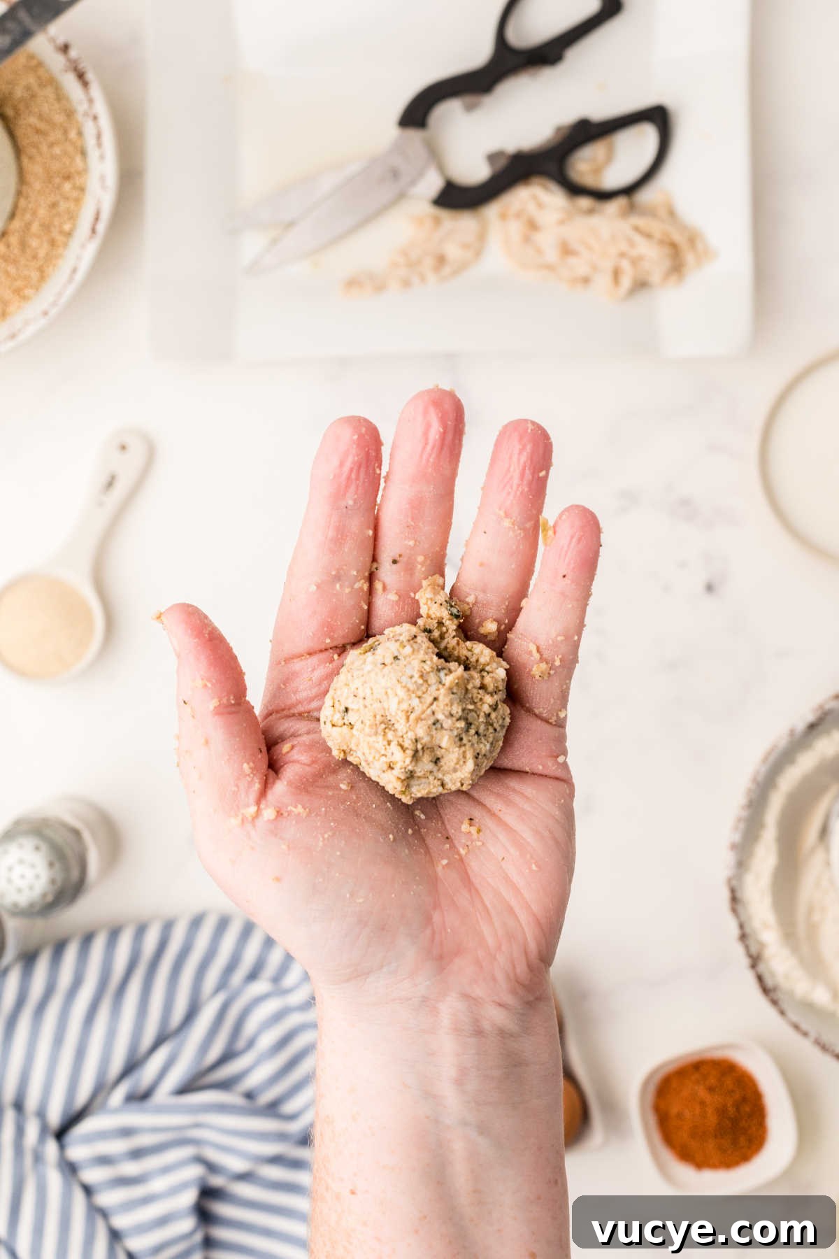 Crispy Fried Boudin Balls: Where to Find & How to Enjoy 5 A hand holding a boudin ball that was just rolled.