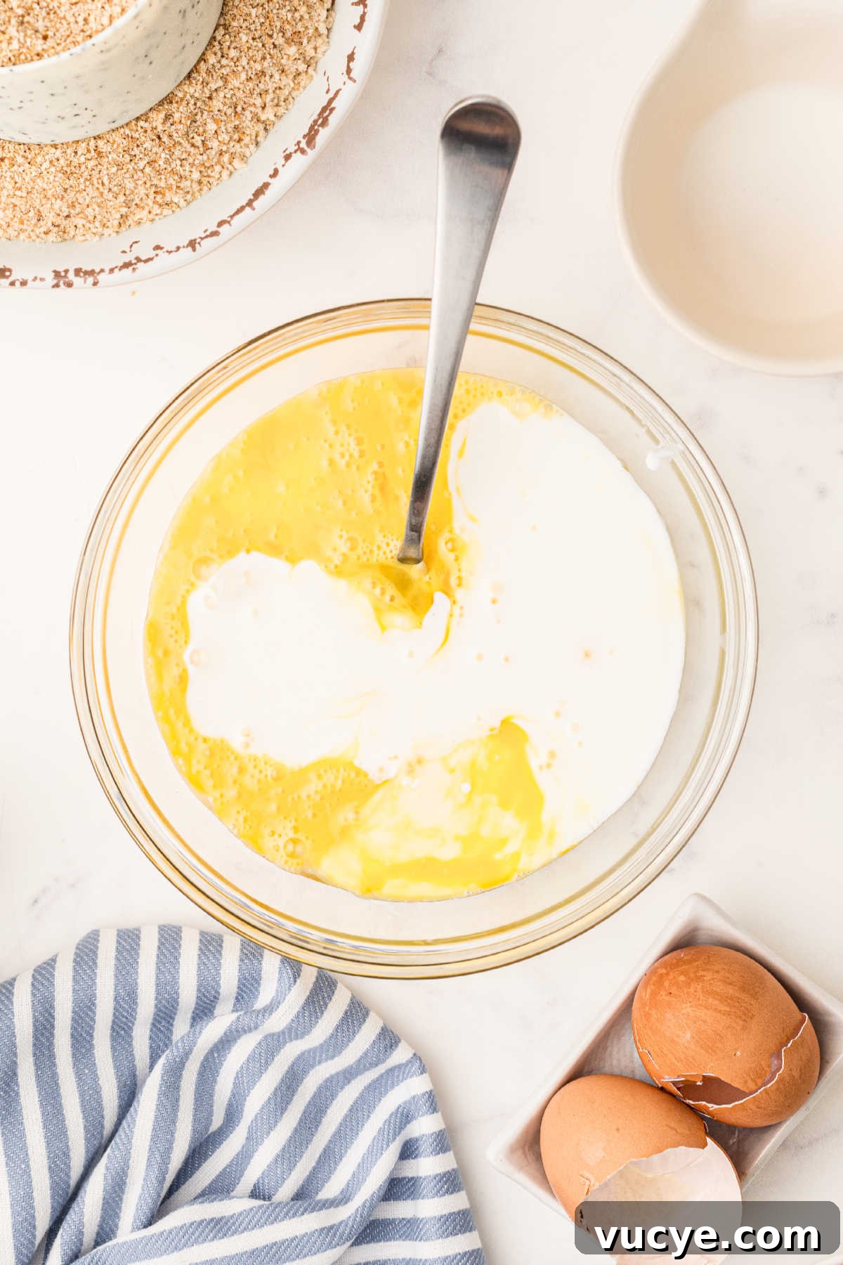 Crispy Fried Boudin Balls: Where to Find & How to Enjoy 7 Buttermilk being mixed into beaten eggs with a fork.