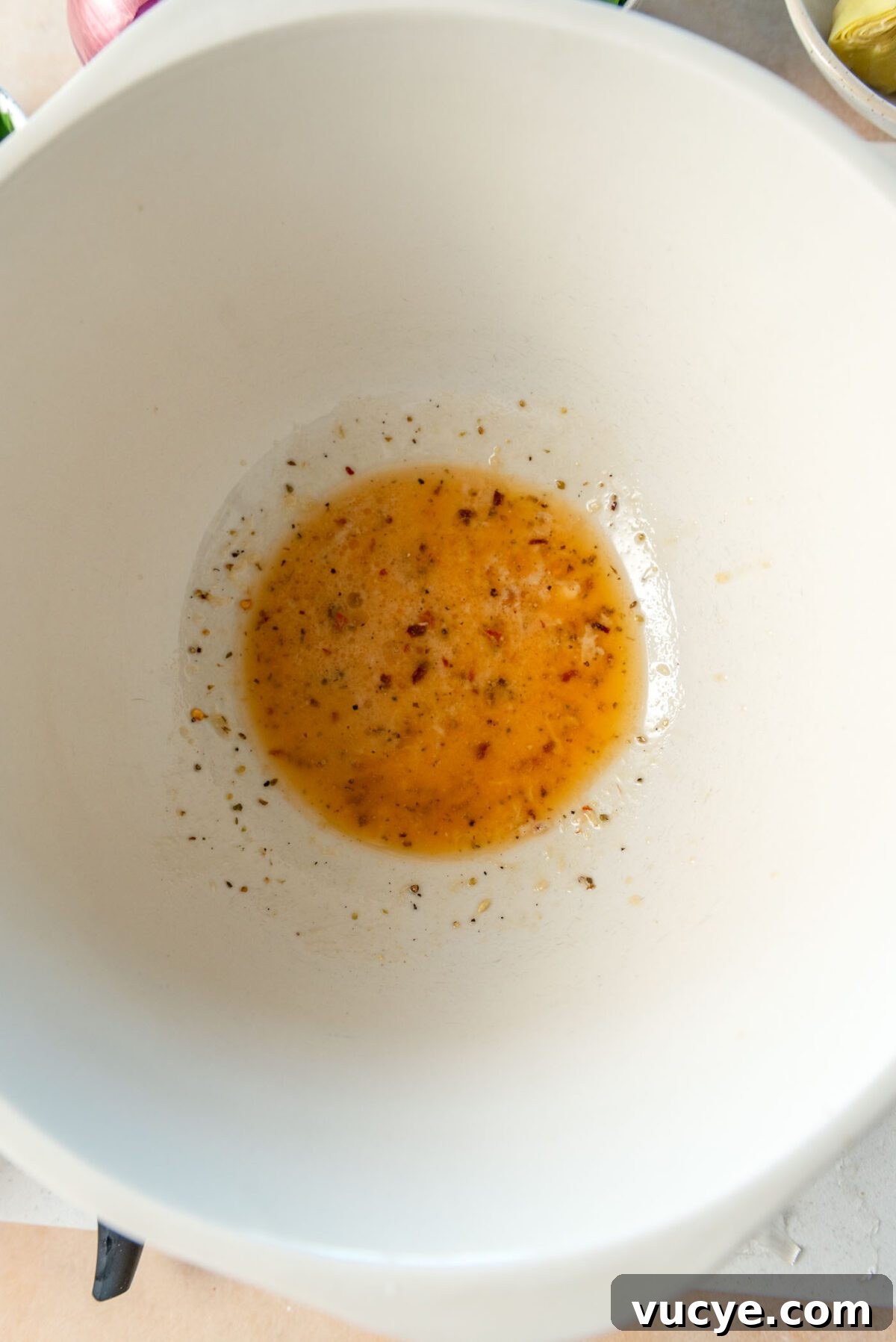 Small amount of vinaigrette in a large bowl.