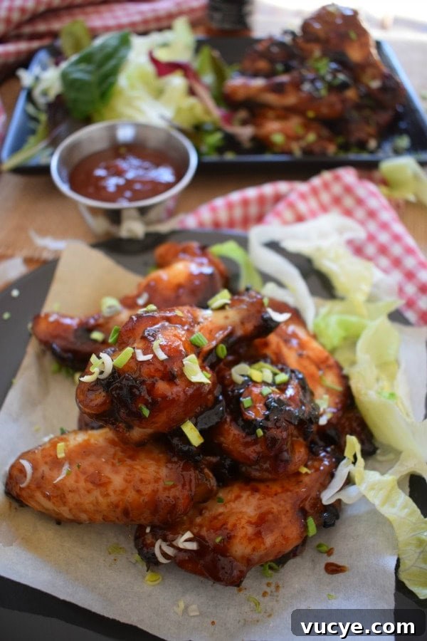 Close up of the sticky honey garlic wings with dipping sauce and lettuce leaves