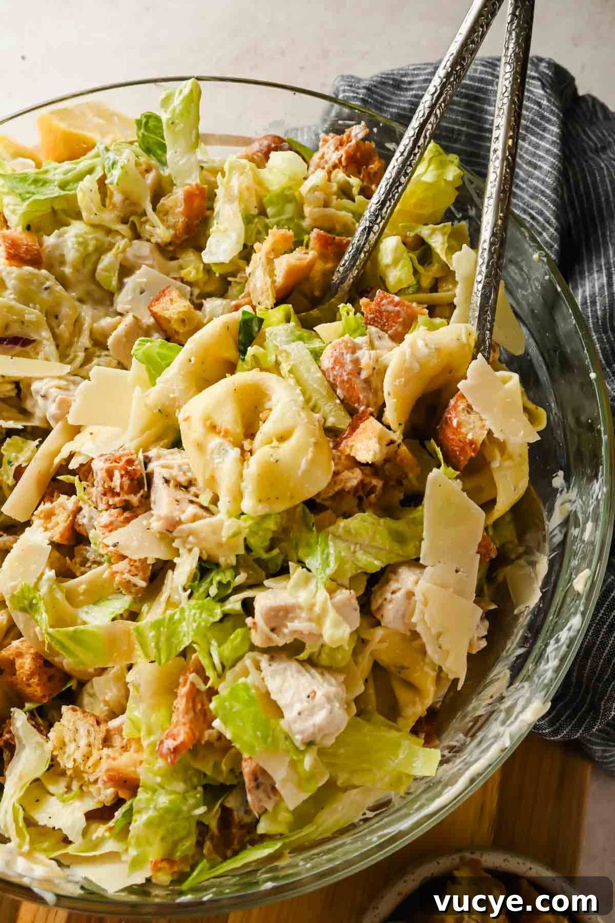 Creamy Caesar Pasta Salad with Crispy Croutons and Parmesan 2 tortellini pasta salad with caesar dressing tossed in glass bowl.