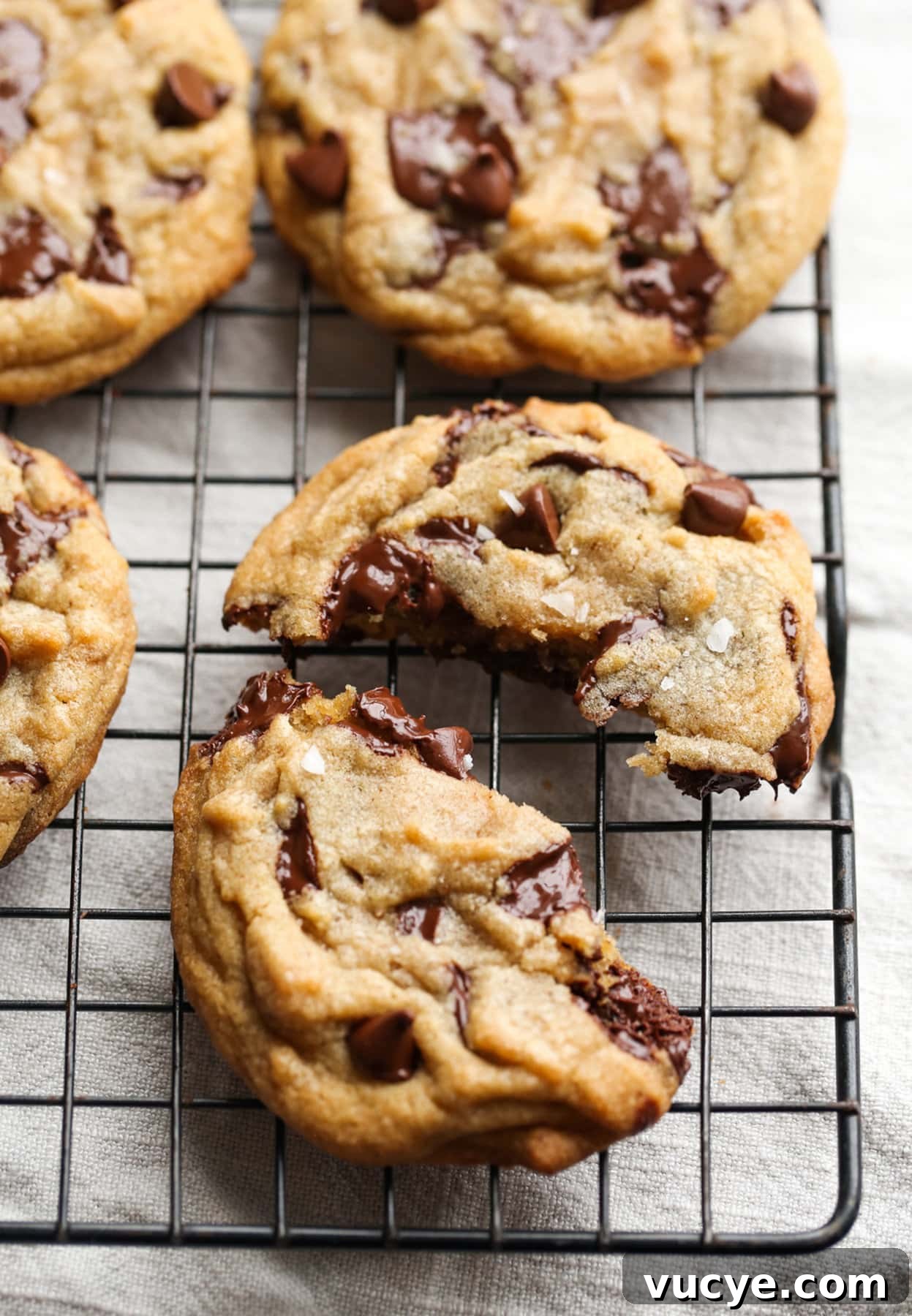 A Brown Butter Chocolate Chip Cookie broken in half on a wire cooling rack