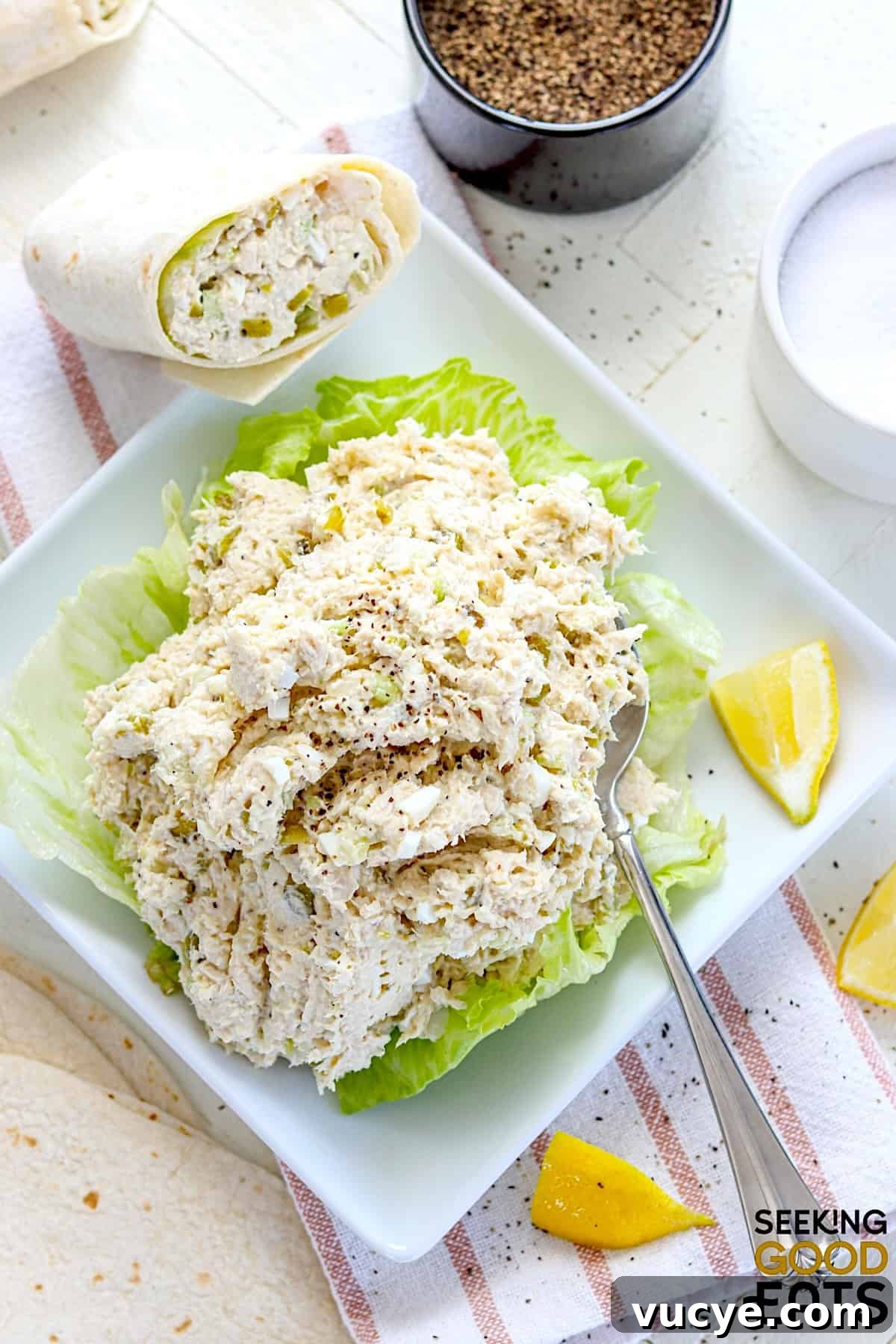 A white square plate with copycat Chick-fil-a chicken salad on a bed of lettuce.