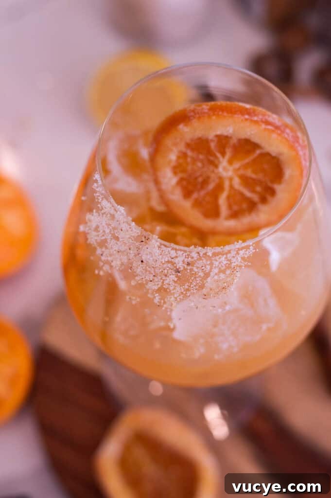 5-Minute Spiced Orange Mocktail — Single-Serve Recipe 2 Close up of an orange mocktail in a wide bottom glass with a candied orange slice.