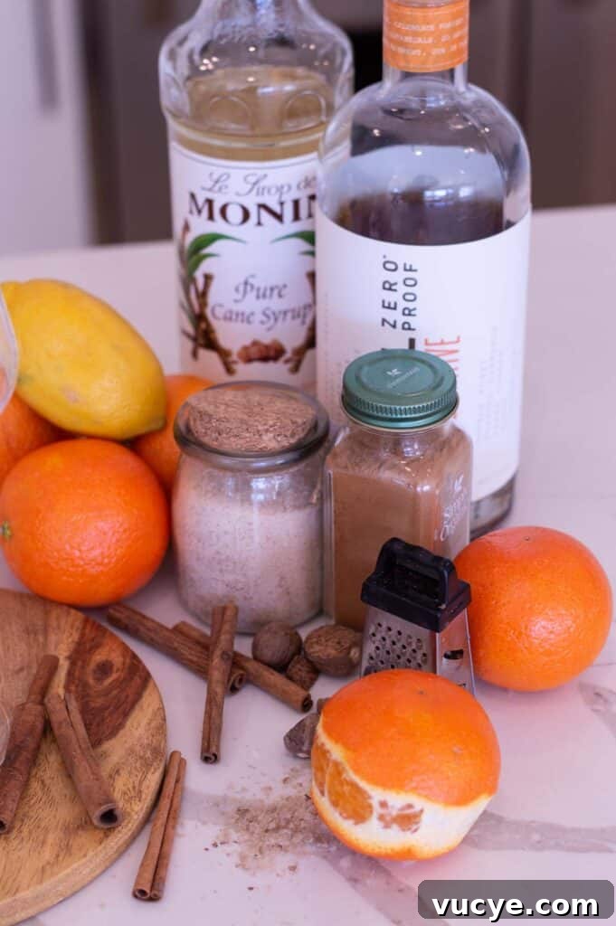 5-Minute Spiced Orange Mocktail — Single-Serve Recipe 3 Ingredients for an Orange Mocktail, including cinnamon sticks, oranges, a lemon, a small grater, zero proof rum, simple syrup, and spices
