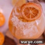 5-Minute Spiced Orange Mocktail — Single-Serve Recipe 8 Glass filled with an Orange mocktail with sugar on the front side of the rim and a candied orange slice.