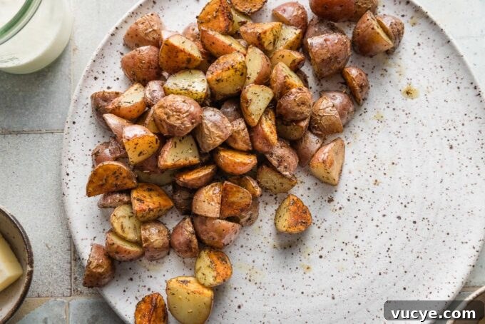 Creamy Dijon Chicken with Roasted Potatoes Recipe 6 Crisp pan-fried potatoes resting on a large white plate.