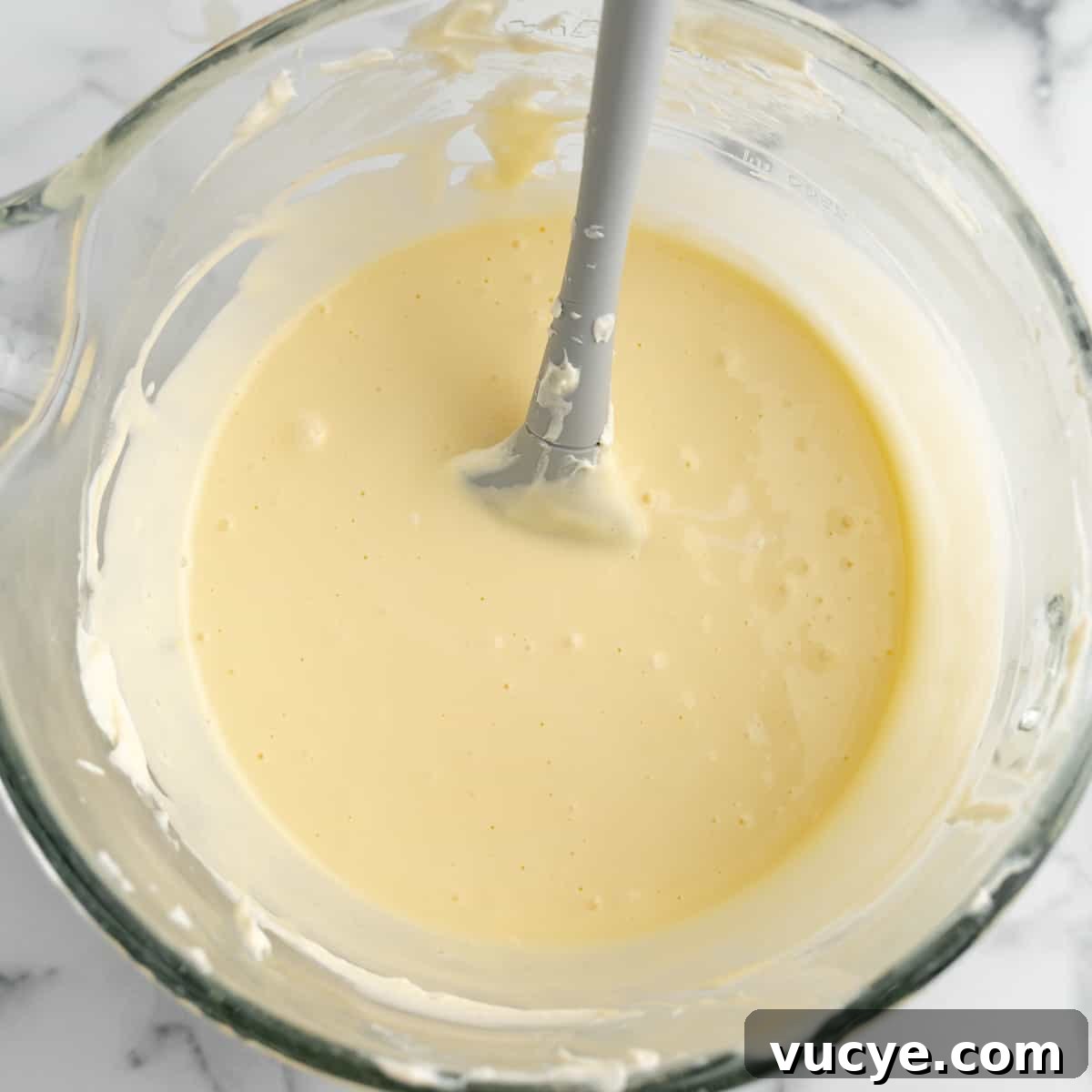 Creamy No-Bake Cheesecake Bars You Can Make Tonight 7 Cheesecake Batter in a clear bowl with a spatula.