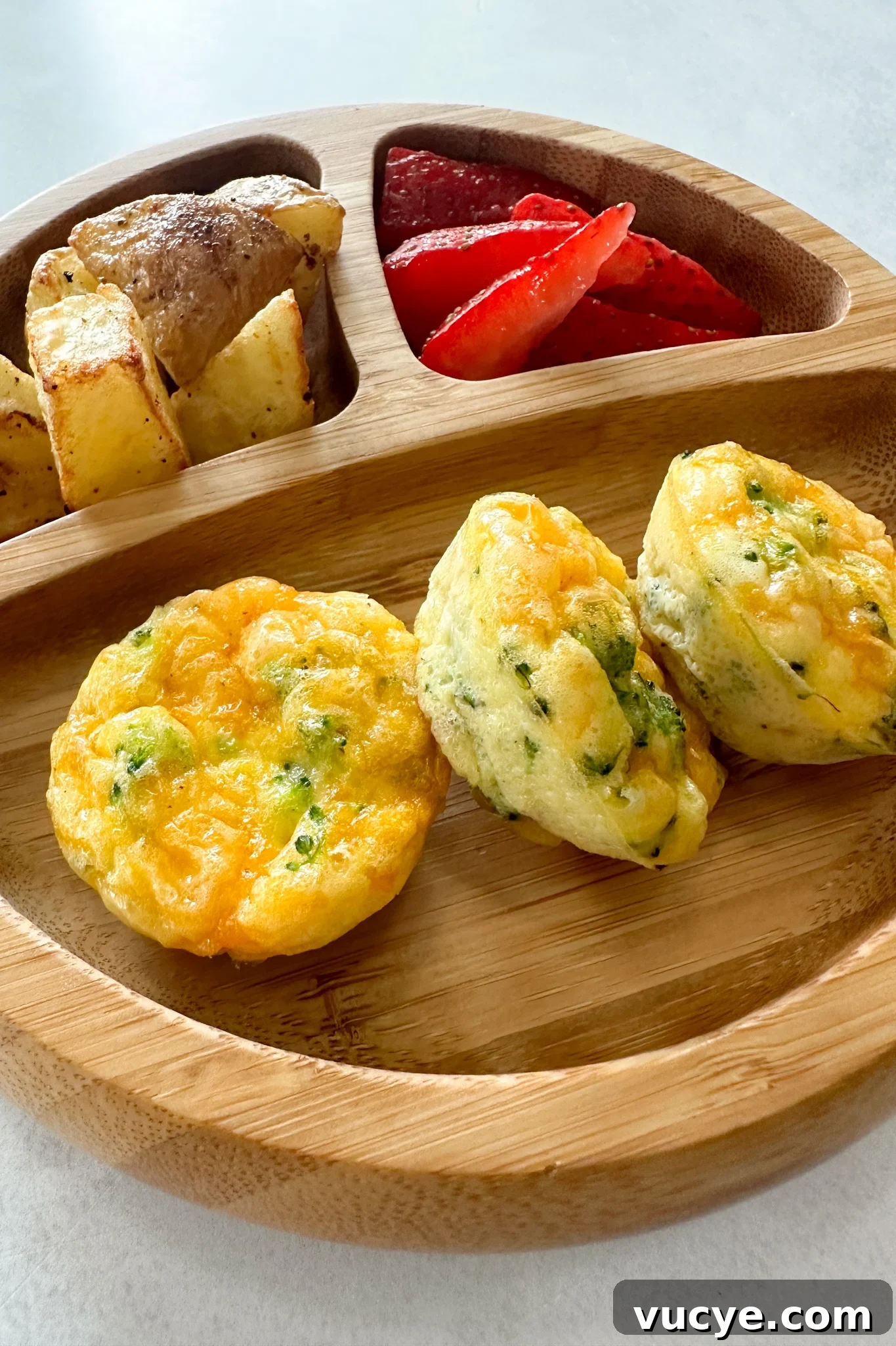 Broccoli egg bites served with fruits and potatoes.