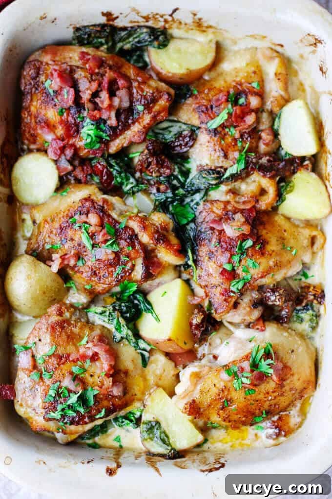 Tuscan chicken and potatoes in baking dish, overhead view