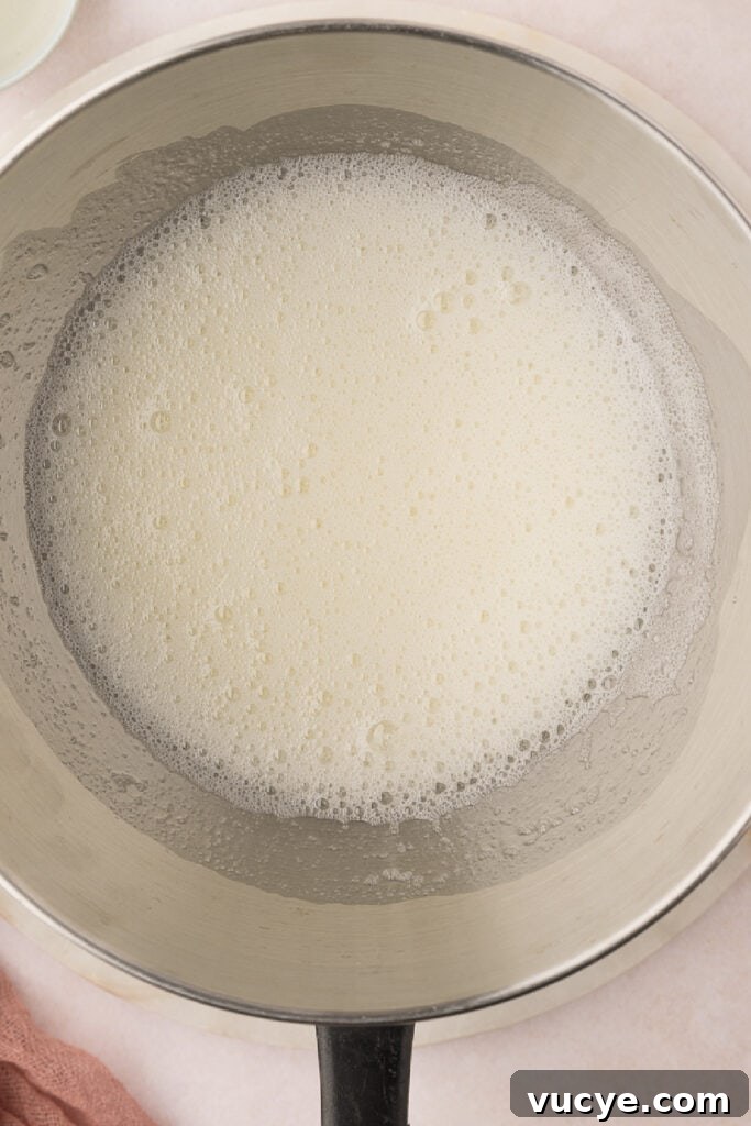 Silky Swiss Meringue Buttercream Recipe for Perfect Frosting 6 Use a whisk to beat the mixture continuously for 4-5 minutes. The mixture will look frothy. Dip your finger into the mixture and feel it between your fingers. If you can feel any grain, keep heating and mixing until you feel the mixture is smooth and slippery. This means the sugar has dissolved.