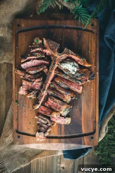 A grilled t-bone steak on a wooden cutting board.