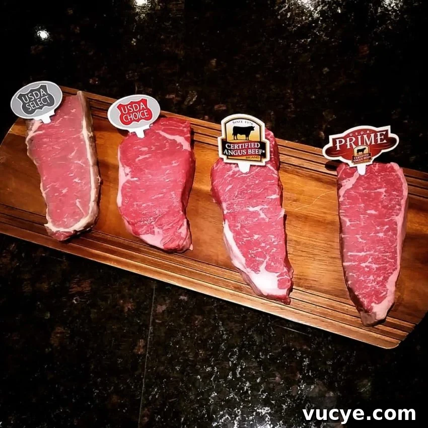 Four steaks on a wooden cutting board.