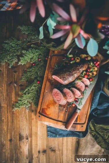 A cutting board with sous vide beef tenderloin on it.