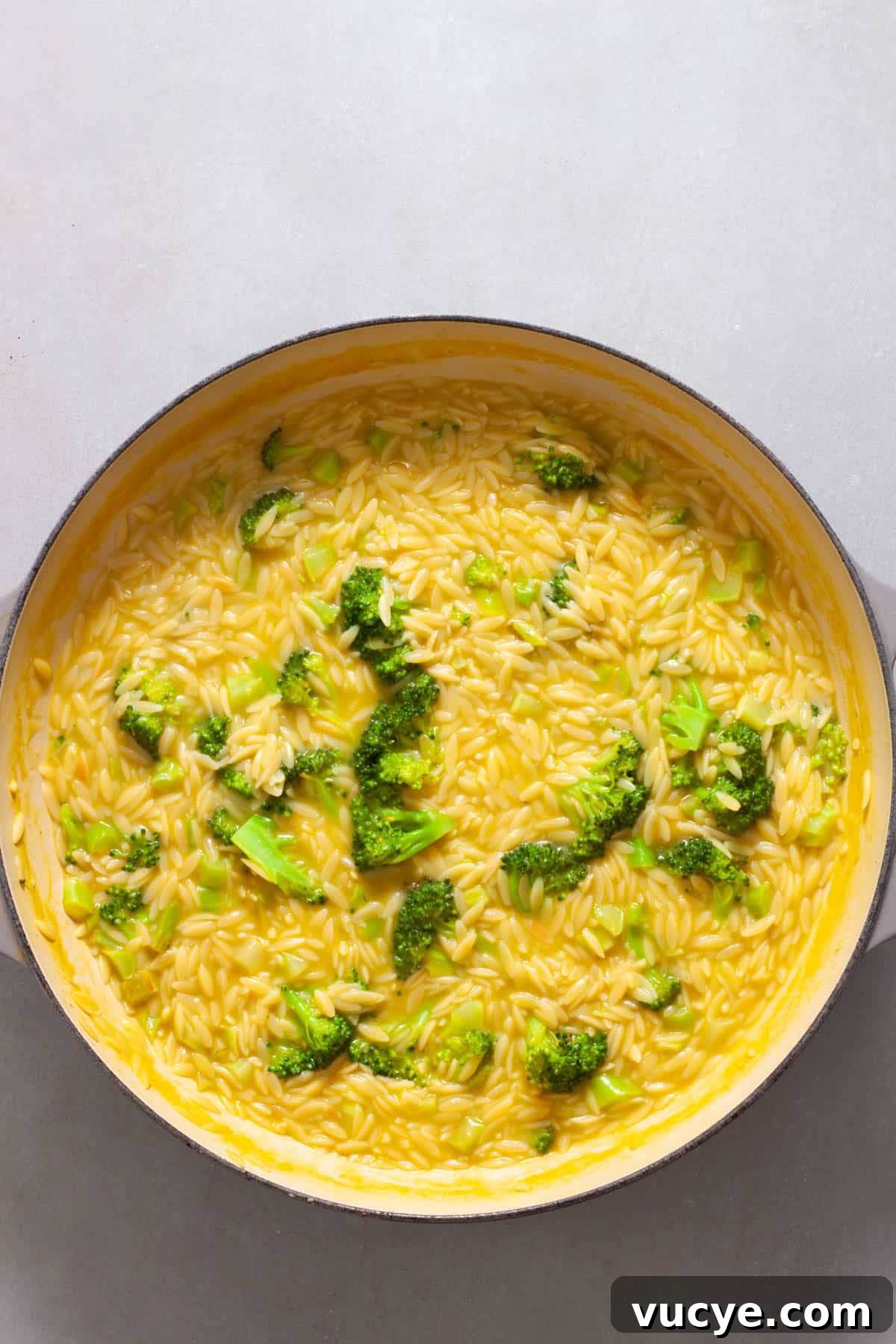 Creamy Broccoli Orzo Pasta with Garlic and Parmesan 8 Broccoli and orzo simmering on a large skillet.
