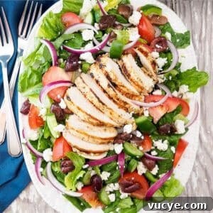 Greek salad with grilled chicken on plate.
