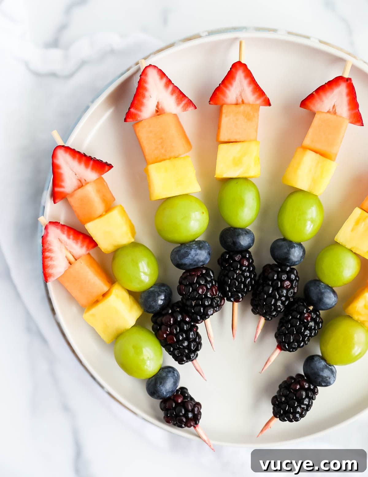 Colorful Rainbow Fruit Skewers Recipe for Parties and Kids 3 Rainbow fruit kebabs on a plate