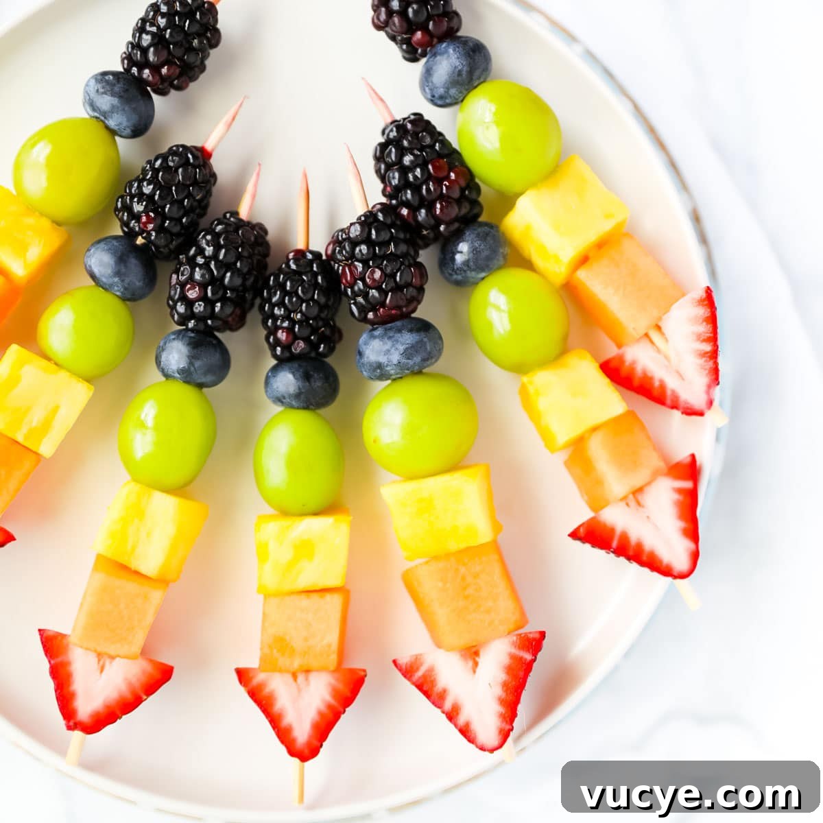Colorful Rainbow Fruit Skewers Recipe for Parties and Kids 5 Blackberries, blueberries, grapes, pineapple, melon, and strawberries on wooden sticks