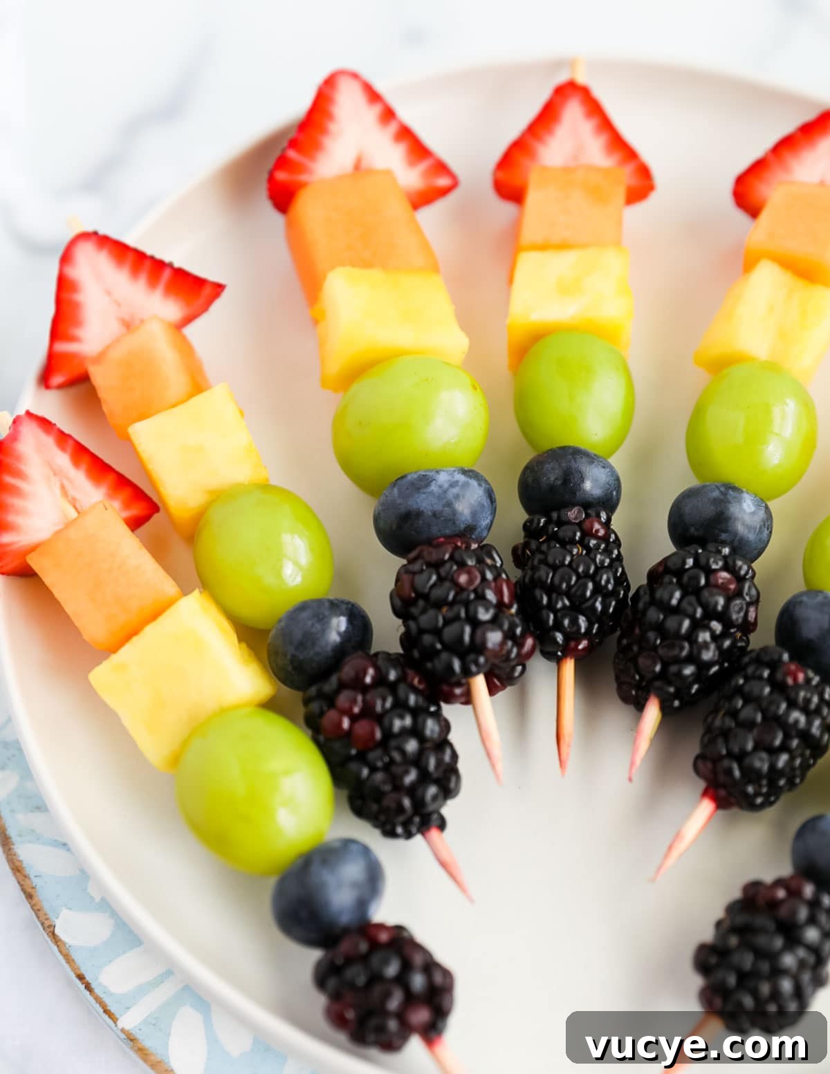 Colorful Rainbow Fruit Skewers Recipe for Parties and Kids 6 Rainbow fruit skewers with strawberries, cantaloupe, pineapple, grapes, blueberries, and blackberries