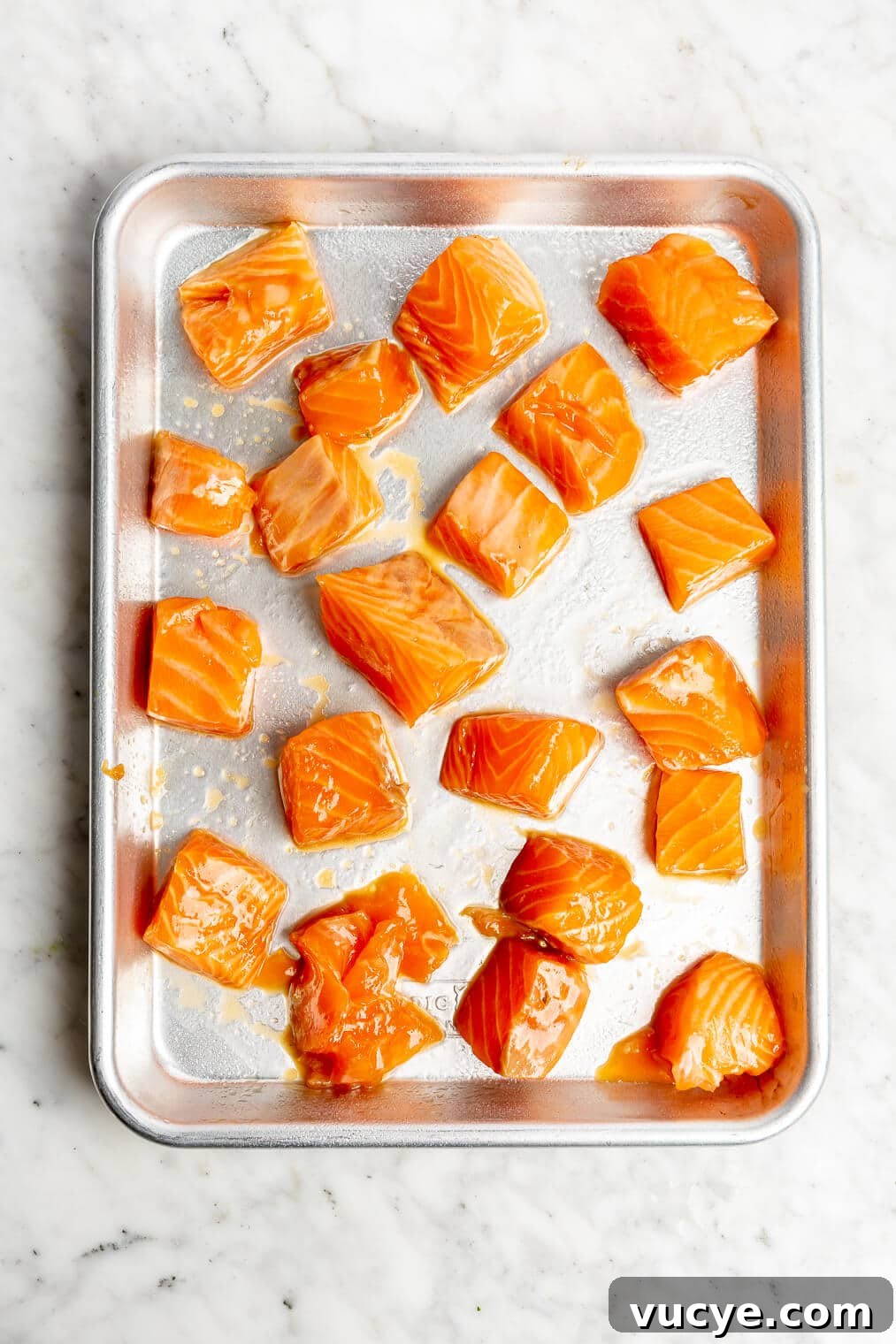 221207_Teriyaki Salmon Bowls-11 Raw, cubed teriyaki salmon on a sheet pan before going into the oven.