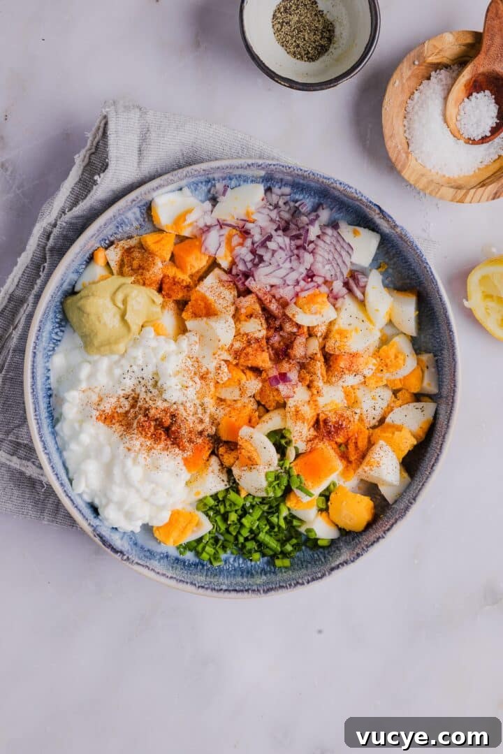 Ingredients for cottage cheese egg salad in a mixing bowl, unmixed