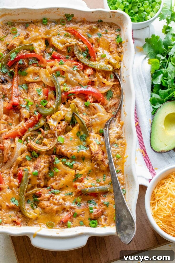 Mexican chicken fajita casserole on wooden board with serving spoon.