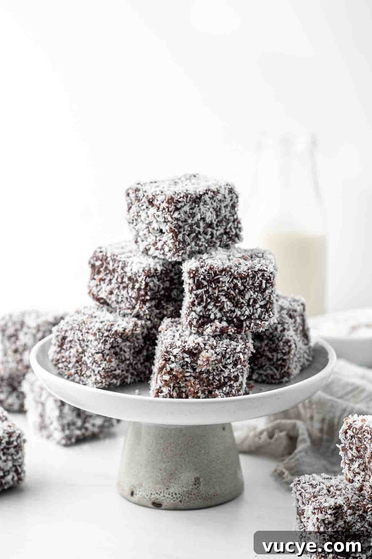 Classic Australian Lamington Recipe: Moist Sponge Cakes with Chocolate & Coconut 3 A stack of classic lamingtons on a cake stand.