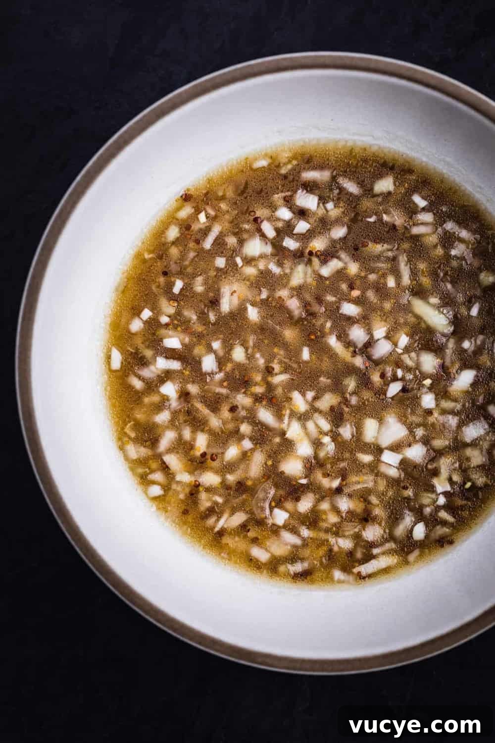 The salad dressing with shallots, maple syrup, mustard, olive oil, salt and pepper.