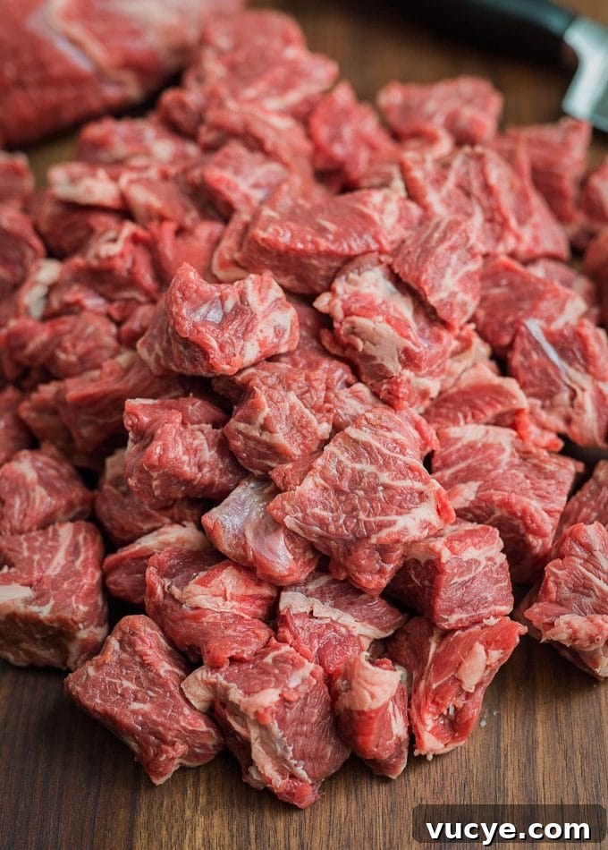 Chilled Chuck Beef Cubes | Striped Spatula chuck beef cut into cubes for grinding on a cutting board