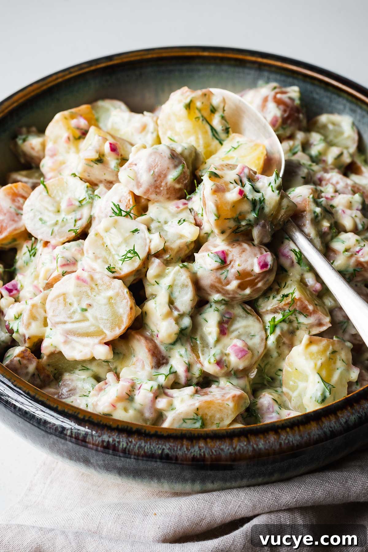 Close-up of a dill potato salad with a creamy yogurt and sour cream dressing.