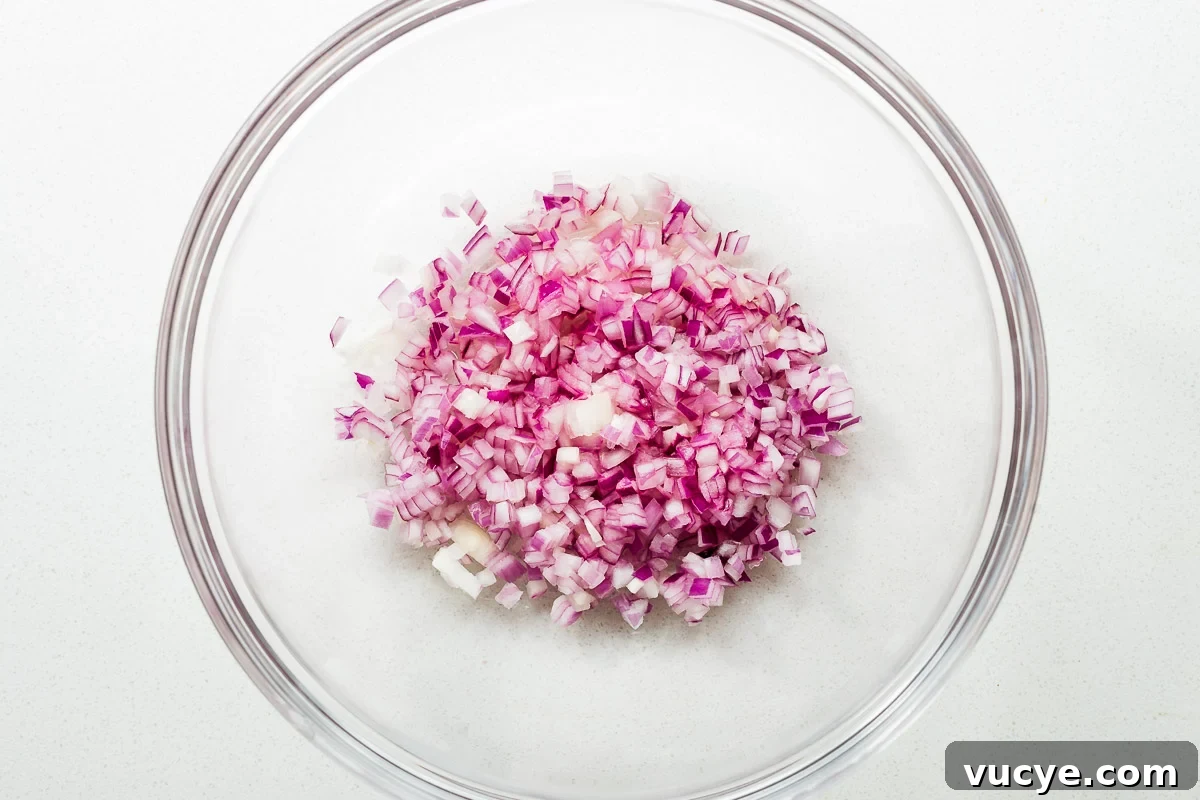 Diced red onions in a large glass bowl.